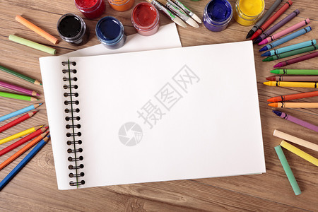 在书桌上写有各种油漆蜡笔和铅笔的空白色图片