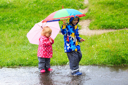 男孩和女孩在雨中玩得开心孩图片