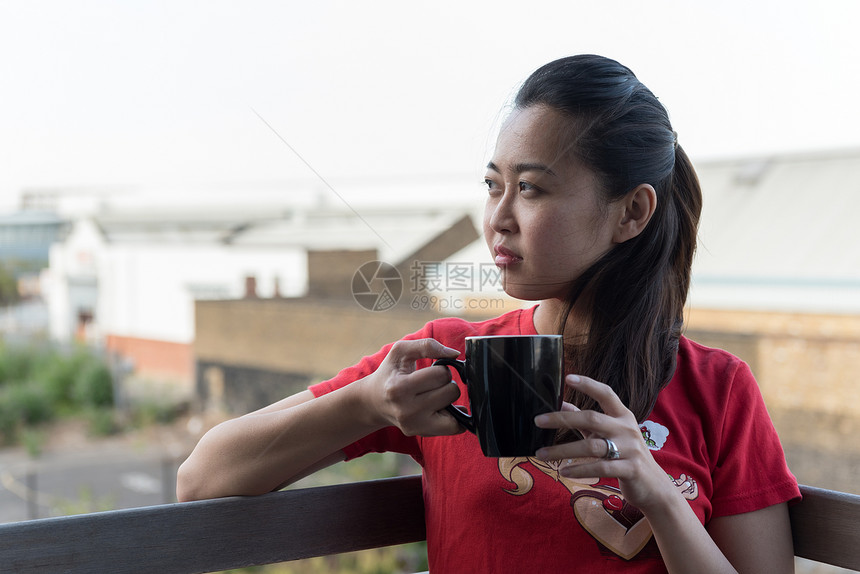 年轻的亚洲女饮咖啡杯图片