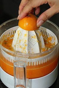 果汁机橙汁机和果汁中用女人手挤图片