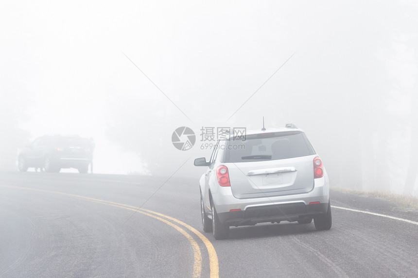 一辆汽车在铺面公路上驾驶由于浓雾可图片