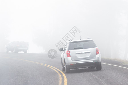 一辆汽车在铺面公路上驾驶由于浓雾可背景图片