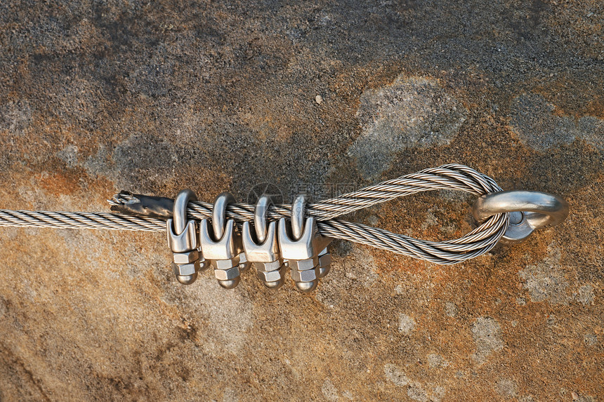 钢丝绳上的实心结铁绞绳由强力螺丝卡钩固定成块锚定在石墙图片