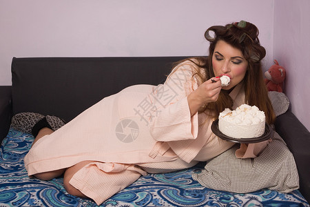 超重的女人吃奶油甜蛋糕图片