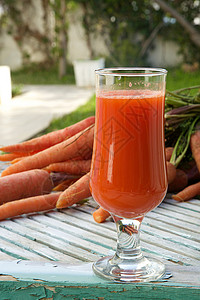 木质表面一杯新鲜的胡萝卜汁背景中高清图片