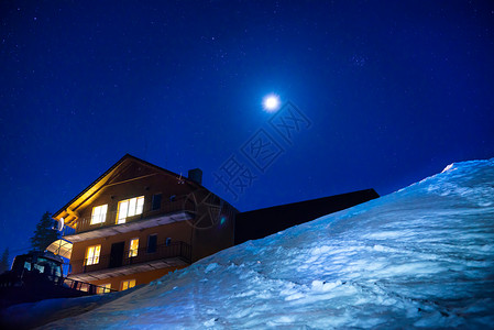 冬天山的圣诞房子在晚上与蓝色黑暗的天空与银河和许多星的雪景乌克兰图片