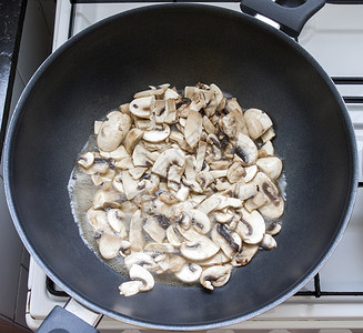 在平底锅里准备鸡肉和蘑菇的烩饭图片