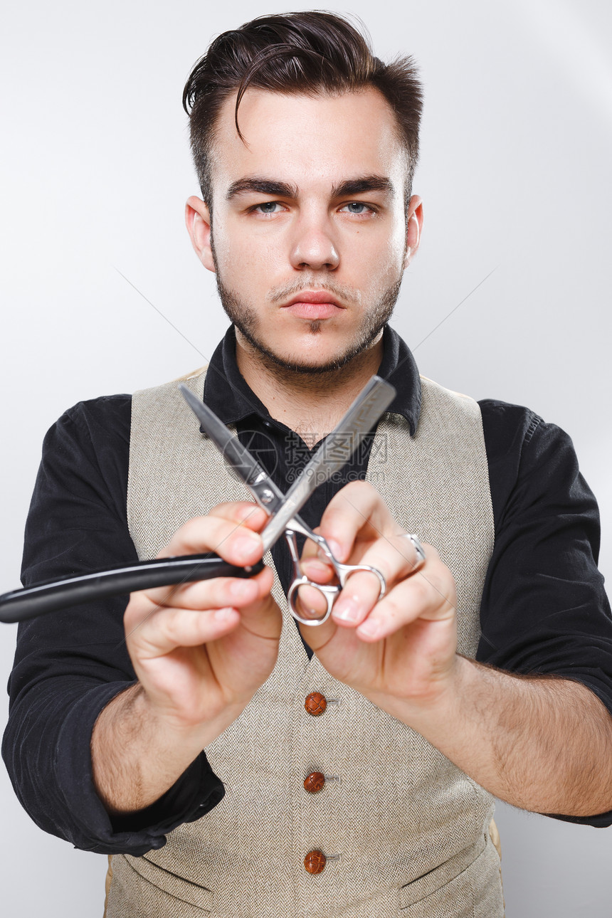 留着胡子的男人用老式直剃刀和剪刀摆姿势图片