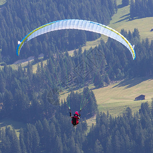 滑翔在瑞士山的业余滑翔伞图片