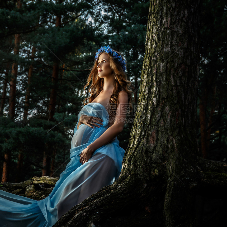 穿着蓝裙子的美丽的孕妇图片