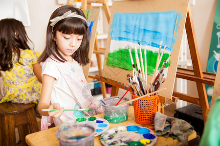 可爱的女孩混合一些颜色在她画的颜色在图片