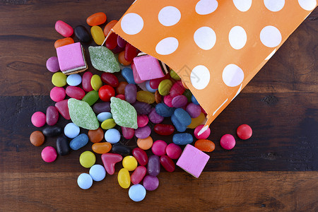 万圣节宴会糖果由橙色波尔卡圆点的派对情趣袋流出在图片