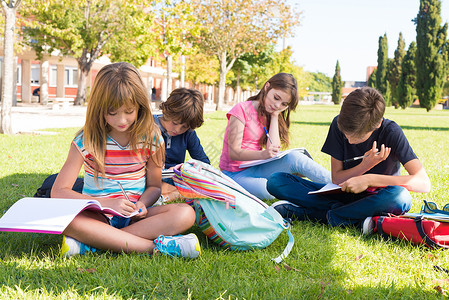 坐在学校草地上的小学生群图片