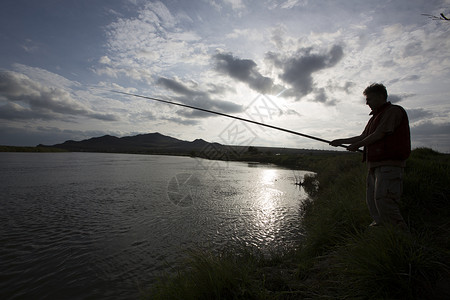晚上在河边钓鱼的渔夫图片