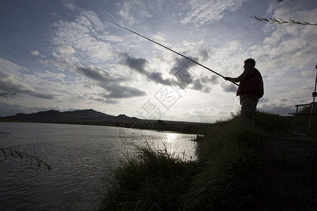 晚上在河边钓鱼的渔夫图片