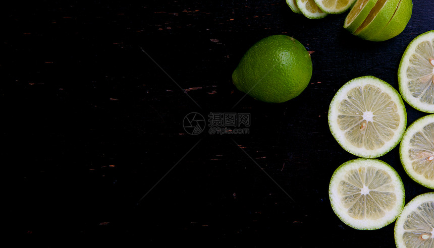 黑木表面的绿色柠檬切片背景图片