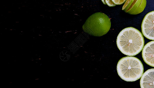 黑木表面的绿色柠檬切片背景高清图片