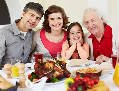 欢乐家庭坐在节日感恩餐桌边图片