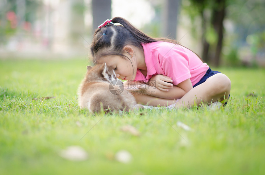 美丽的亚洲女孩在青草上玩耍和一个西比莉图片