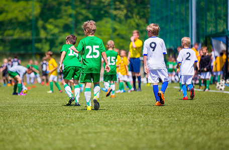 年轻男孩玩足球比赛球员横穿足球图片