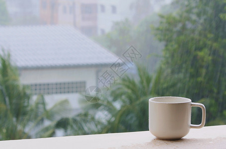 城市背景下雨天的咖啡杯图片