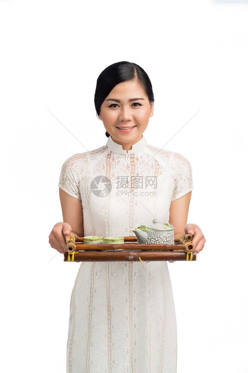 亚洲女人拿着茶壶和茶杯的托盘图片