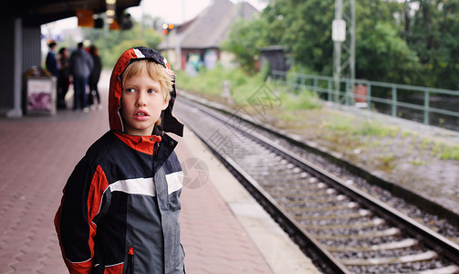 岁男孩站在火车站等火车图片