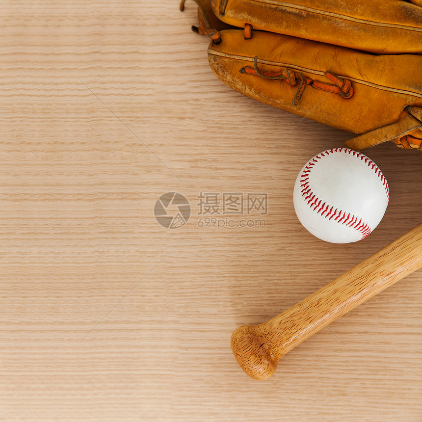 带球和棒球手套在木本背景上打图片