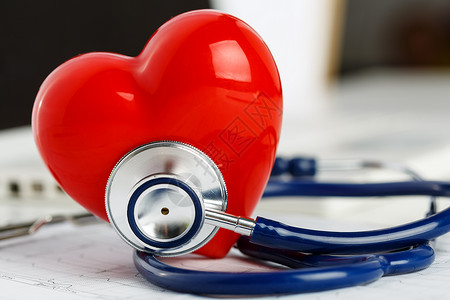 医用听诊器头和红色玩具心躺在心电图表特写上医疗帮助预防疾病预防或保险概念心脏病学护理健康背景图片