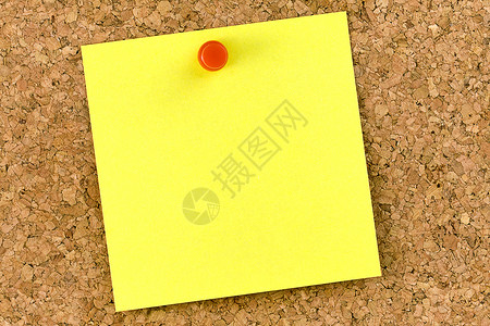 用红色图钉贴在软木板上的空白黄色postit图片