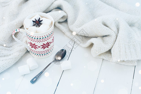 舒适的冬季家居背景一杯热可棉花糖和八角茴香旧书和白色木板背景上的图片