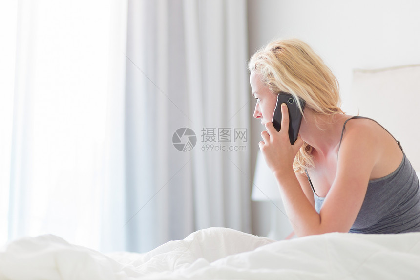 在家里的床上用手机的年轻女士的画像疲倦困的女人一大早就在床上图片