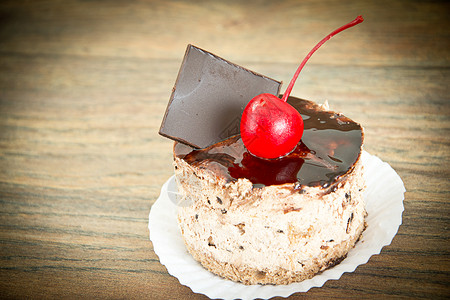 水果蛋糕巧克力和樱桃在老旧的回图片