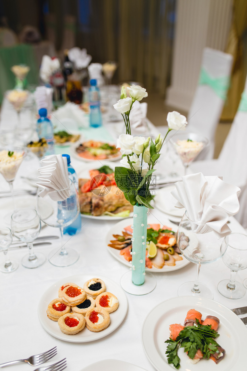 为节日宴会装饰的餐桌配有饮料和小吃图片