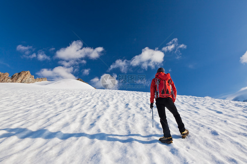 一名男登山者在冰河上爬山图片