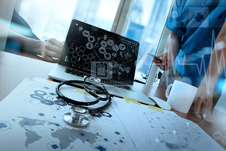 团队医生在医疗工作区办公室使用笔记本电脑和医疗网络媒图片