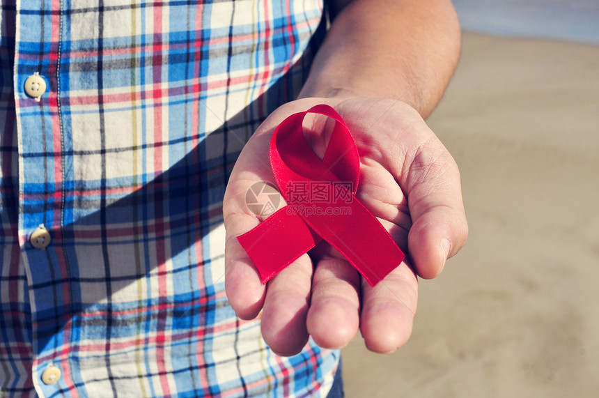 一名年轻男子用红色防艾滋宣传丝带紧闭他手上的一位年轻人图片