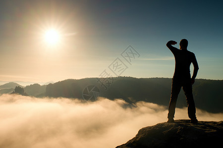 岩石帝国公园岩石尖峰上的风趣男孩正注视着雾蒙图片