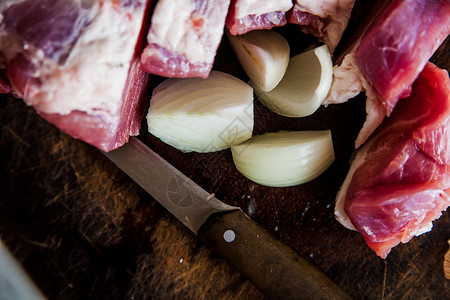木砧板猪上的切肉洋葱和钢刀图片