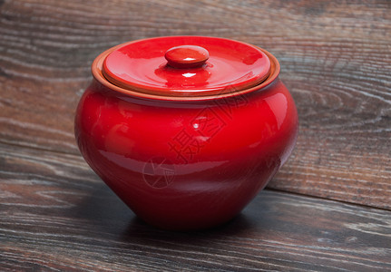 桌上带盖的红陶罐背景图片