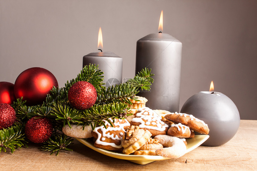 木桌上的圣诞饼干和蜡烛图片