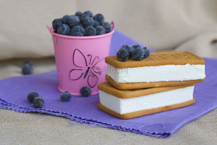旧木表面上的新鲜蓝莓三明治冰淇淋图片