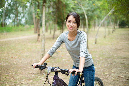 亚洲年轻妇女在农村骑自行图片