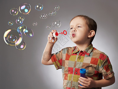 有趣的小男孩吹肥皂泡快乐的孩子图片