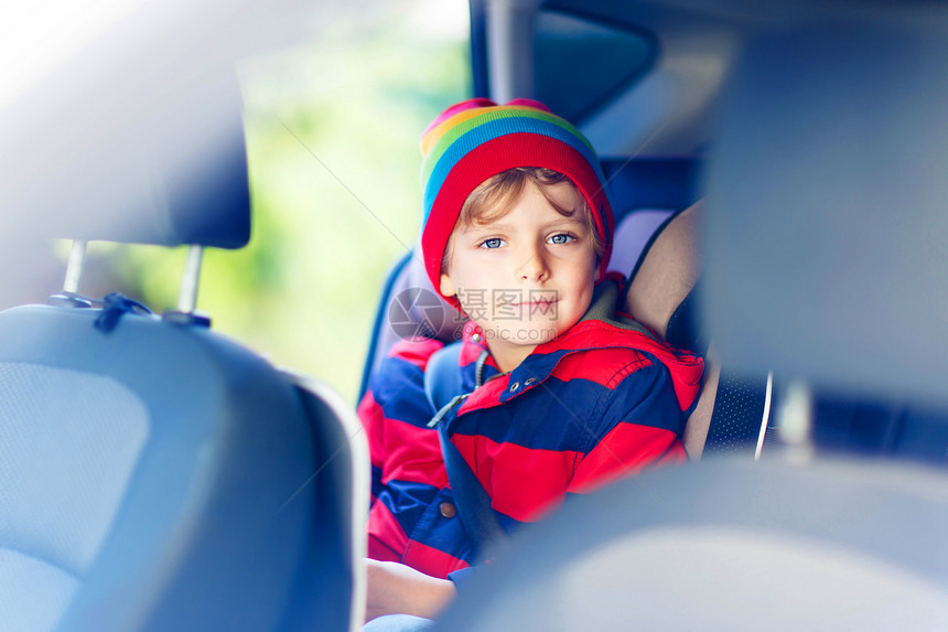 坐在车里的学龄前小孩男的画像带安全带的安全汽车座椅上的儿童与孩子和交通法概图片