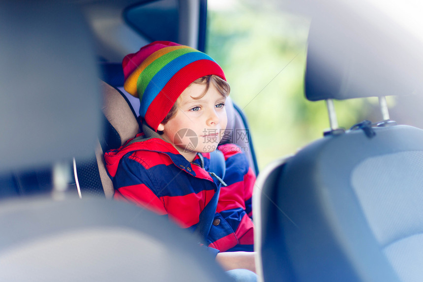 可爱的学龄前儿童男孩坐在车里带安全带的安全汽车座椅上的儿童与孩子和交通法概图片