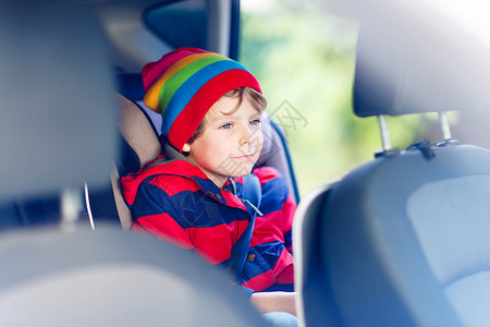 违反交通法规可爱的学龄前儿童男孩坐在车里带安全带的安全汽车座椅上的儿童与孩子和交通法概背景