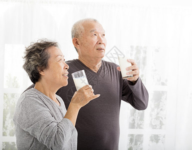 喝牛奶的愉快的亚裔资深夫妇图片
