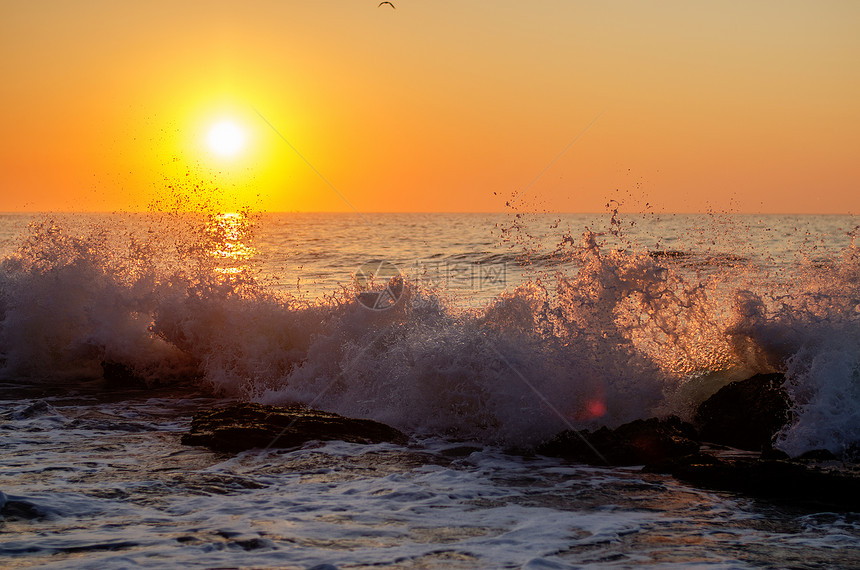 海浪在日落背景图片