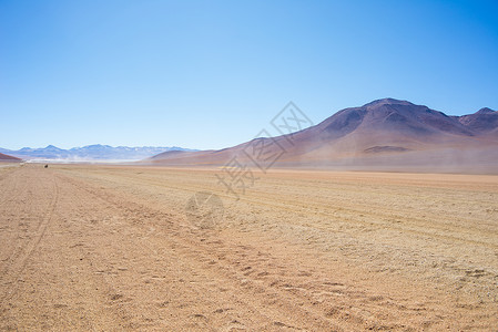 高海拔的土路与安第斯高地的沙质漠和贫瘠的火山范围背景图片